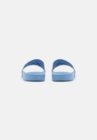 Blå gummisandaler med flat såle og brede stropper, med en glatt tekstur og et enkelt, ergonomisk design.