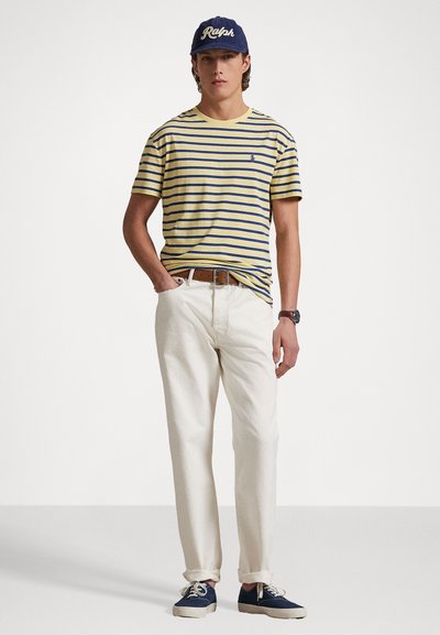 Ριγωτό κίτρινο και ναυτικό μπλουζάκι, λευκό παντελόνι, μπλε αθλητικά και ναυτικό καπέλο με κέντημα "Ralph". Διαθέτει κλασική γραμμή και casual σχέδιο.