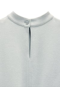 Jasnoniebieska, teksturowana dzianina z małym zapięciem na guzik i rozcięciem przy kołnierzu. Prosty, minimalistyczny design.