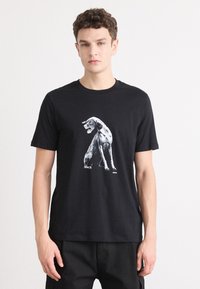 Black cotton t-shirt featuring a graphic of a dog in white. Short sleeves and crew neck. Simple, minimalist design with no visible accents.