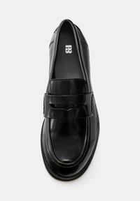 Črni mokasini iz lakiranega usnja z okroglim nosom, gladko površino, dekorativnim trakom in nežnimi detajli šivov.
