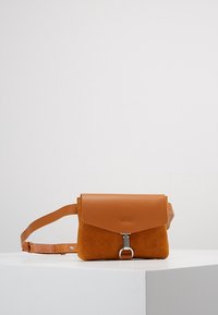 Borsa a tracolla in pelle e suede color nocciola con forma rettangolare, chiusura a patta magnetica e accessori in metallo argentato su una tracolla in tessuto.
