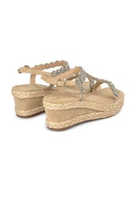Sandali a zeppa beige con suola in juta intrecciata, parte superiore testurizzata con cinturini a forma di arco, e decorati con strass sui cinturini.