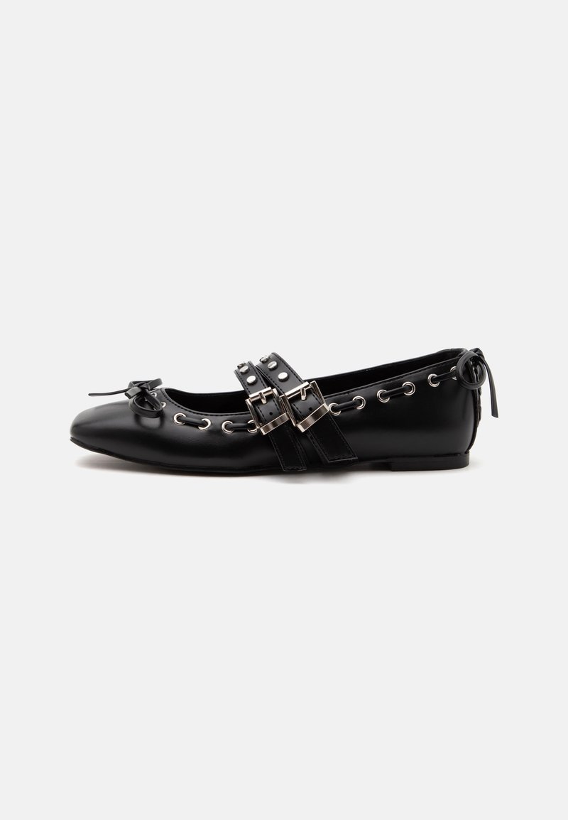 Chaussure de ballet plate noire avec doubles brides à boucle, œillets argentés et petit nœud près de l’orteil arrondi sur fond blanc.