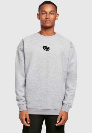 Gray crewneck sweatshirt made of fabric featuring a small black citrus slice graphic on the chest. Relaxed fit with ribbed cuffs and hem.