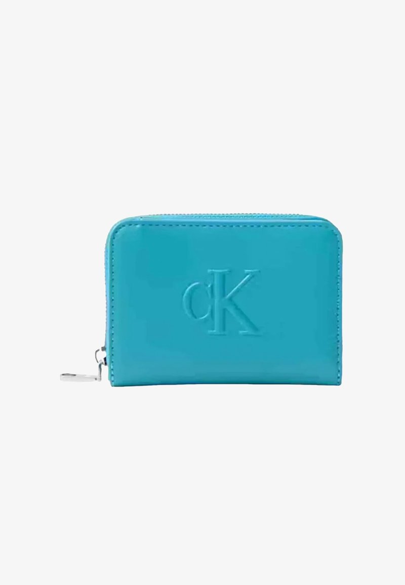 Portafoglio in pelle turchese con logo "cK" in rilievo, chiusura con zip, texture liscia, bordi arrotondati e dettagli in metallo argentato.