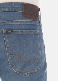 Denim jeans met een lichte blauwe wassing, met een leren Lee merkpatch op de taille en traditionele gestikte achterzakken.