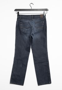 Jeans de mezclilla azul oscuro, diseño de pierna recta, que presentan dos bolsillos traseros con detalles de costura curvada, colgando de una percha negra.
