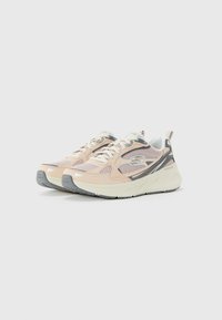 Une paire de baskets Skechers beige et grise avec des lacets blancs et des semelles rembourrées sur un fond blanc uni.