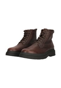 Bruna läderankelboots med texturerad yta, snörning och en tjock svart gummisula för ökad komfort och stabilitet.