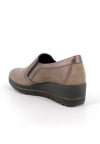 Scarpa slip-on con tomaia di un marrone chiaro a motivo, dettagli metallici sul tallone e suola nera spessa per maggiore altezza e comfort.