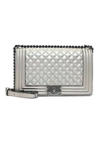 Bolso de mano plateado acolchado con una correa de cadena, que presenta una forma rectangular, textura brillante y un detalle central de cierre de hardware.
