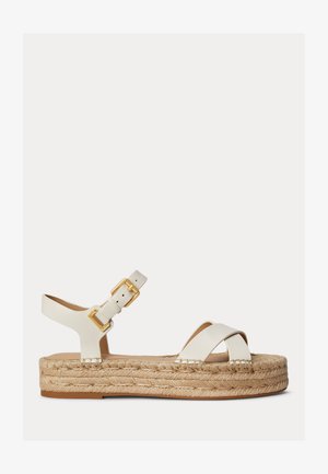 Sandale à plateforme en cuir blanc avec des brides croisées, une boucle dorée et une semelle en jute tressé.