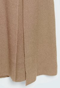 Abito lavorato a maglia in marrone chiaro, con una texture a coste e dettagli con spacco laterale. Il tessuto è liscio e presenta un motivo uniforme su tutta la superficie.