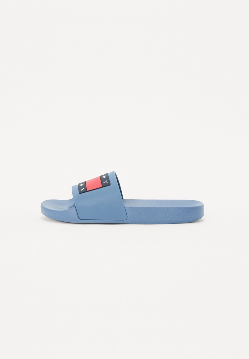 Blue slide sandal made of rubber, featuring a wide strap with a red and black graphic. Simple design with a flat sole and smooth texture.
