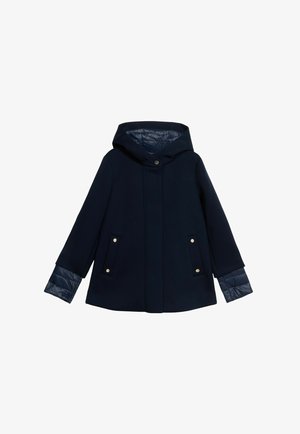 Marineblauwe jas met capuchon, met een gladde buitenstof, gequilte mouwaccenten en twee voorzakken met gouden hardware.