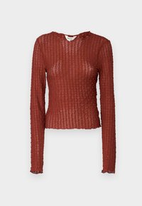 Maglietta a maniche lunghe di colore ruggine, caratterizzata da un design a maglia testurizzata con scollatura e orlo leggermente ondulati per un tocco di dettagli.