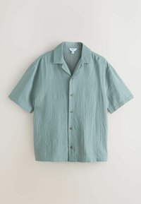 Rövid ujjú, világoszöld, gombos ing széles gallérral, fehér háttéren kiterítve.