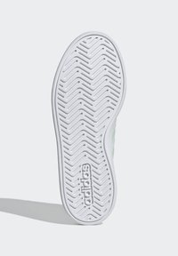 Bijeli potplat cipele s uzorkom zupčanika u obliku cik-cak i utisnutim logotipom marke. Zaobljenog oblika s debelim bočnim rubovima. Ravan, teksturirani površinski sloj.