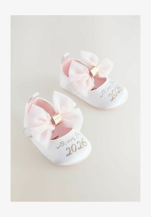 Valkoiset taaperokenkä, joissa on satiinipinta, suurilla vaaleanpunaisilla nauhoilla ja kultaisilla yksityiskohdilla. Teksti "Syntynyt vuonna 2026" on brodeerattu jokaiseen kenkään.