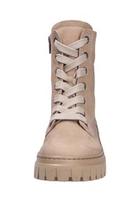 Bottine en cuir tan avec des lacets proéminents, bout arrondi et semelle en caoutchouc épaisse. Présente des détails de couture et une fermeture éclair sur le côté pour plus de facilité.