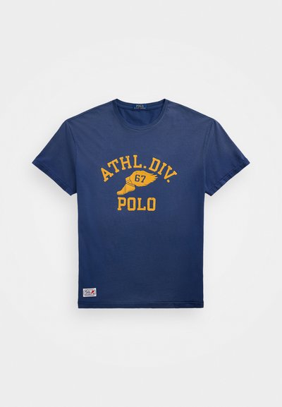 Ναυτικό μπλε βαμβακερό T-shirt με κοντά μανίκια, που διαθέτει κίτρινο γραφικό κείμενο "ATHL.DIV. 67 POLO" και ένα λογότυπο στην κάτω ραφή.