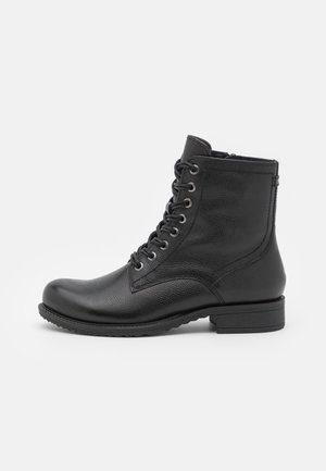 Botas de tobillo de cuero negro con un acabado texturizado, que presentan cordones, una puntera redondeada y un tacón bajo de bloque. Suela de goma ligera.