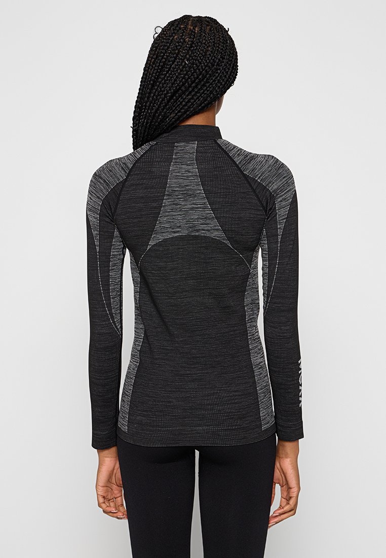 Zwart sportshirt met lange mouwen, voorzien van een textuurdesign, raglanmouwen en contrasterende grijze accenten op de rug.