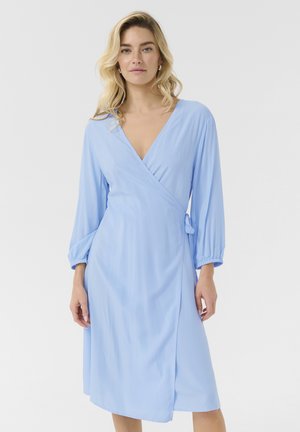 Vestido envolvente azul claro con mangas largas, un escote en V profundo y un detalle de lazo lateral. Fabricado en una tela suave y fluida con un corte por la rodilla.