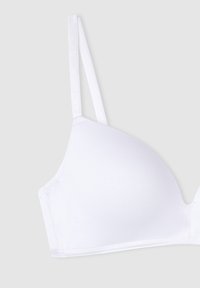 Sino wireless bianco realizzato in cotone liscio, con spalline sottili regolabili e un design senza cuciture, senza hardware o decorazioni visibili.