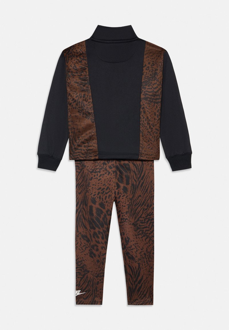 Trainingsanzug mit einem schwarzen Oberteil mit braunen Tierdruck-Akzenten und passenden braunen Leggings mit einem ähnlichen Muster. Das Material wirkt glatt und atmungsaktiv.