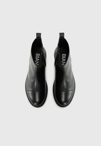 Bottines en cuir noir avec une finition lisse, fermeture éclair et bout arrondi. Présente un détail de couture subtil à l'avant.