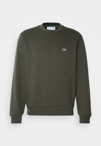 Sweat-shirt vert foncé à manches longues et col rond, avec petit logo crocodile Lacoste brodé sur la poitrine gauche.