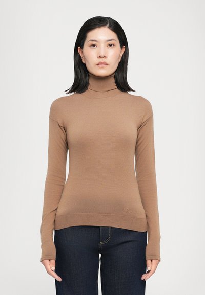 Pull en maille douce, marron, à col roulé ajusté avec des manches longues ; présente un ourlet côtelé et un logo discret en bas.