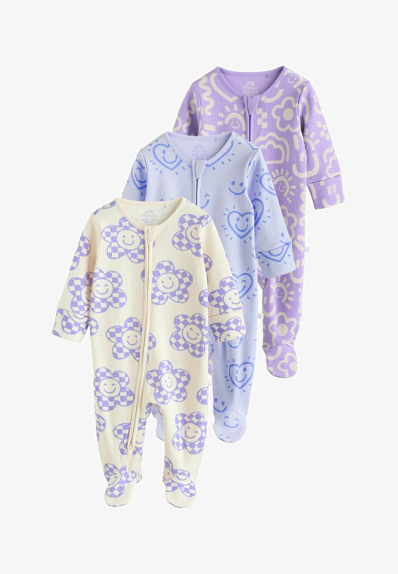 Three long-sleeve baby onesies with feet in cream, light blue, and purple, each with smiling flower or heart patterns and front zippers.