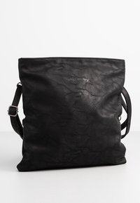 Borsa tote in pelle nera con superficie texturizzata, dotata di una singola tracolla regolabile e logo in rilievo sul davanti.