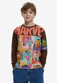 Hosszú ujjú barna ing, élénk, képregény-stílusú Hulk grafikákkal, és a "MARVEL" felirat vastag betűkkel a mellkason.