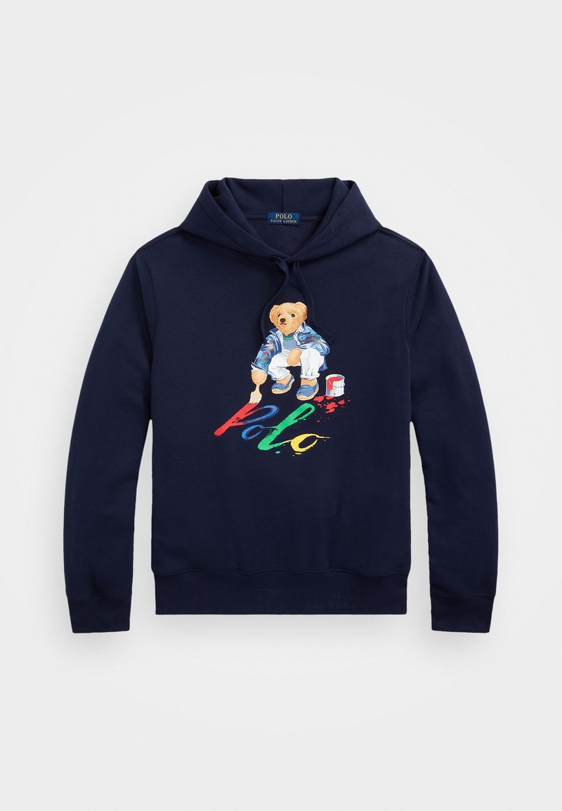 Mörkblå hoodie med dragsko på huvan, med en björn i färgglada kläder och texten "Polo" i livfulla färger. Mjukt tyg.