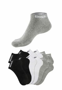 Gray ankle socks with white branding, alongside a set of six socks in black, white, and varying shades of gray. Cotton blend, textured finish.