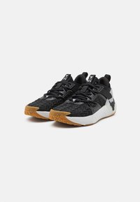 Svarta träningsskor med texturerad ovandel, grå detaljer och en gummisula med ett triangulärt mönster. Säkert snör- och remstängning.