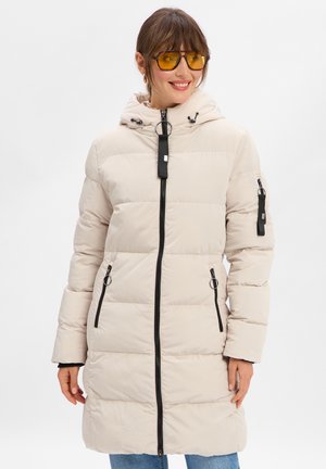 Beige pufferjack met een capuchon, ritssluiting aan de voorkant en zwarte accenten. Voorzien van zijzakken en een gestructureerd gequilt ontwerp.