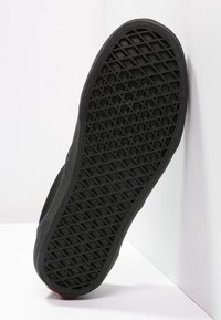 Semelle de chaussure en caoutchouc noir avec un motif en losanges texturé et des bords renforcés, conçue pour l'adhérence et la durabilité.