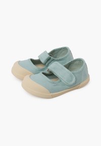 Scarpe in tela azzurro chiaro con punta arrotondata, suola in gomma crema e una fascia in velcro sulla parte superiore per una vestibilità sicura.