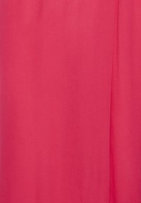 Tissu rouge avec un pli vertical subtil sur le côté droit, montrant une texture lisse et une légère variation de couleur.