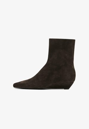 Dunkelbraune Wildleder-Stiefeletten mit spitz zulaufender Zehenpartie und niedrigem Keilabsatz, mit glatter Textur und nahtlosem Design.