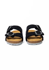 Sandales noires en feutre avec deux sangles réglables, boucles en argent et semelle en liège. Semelle en caoutchouc grise avec un motif de talon texturé.