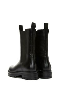 Black leather ankle boots with elastic side panels, rounded toe, chunky black sole, and pull tabs for easy wear. Textured finish.
