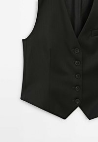 Svart skräddarsydd väst med fem framknappar och en V-formad nederkant på vit bakgrund.