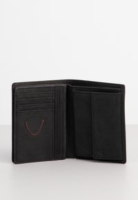 Portafoglio in pelle nera con molteplici slot per carte, una texture liscia e un dettaglio di cucitura rossa a contrasto. Si apre per rivelare un ampio scomparto.
