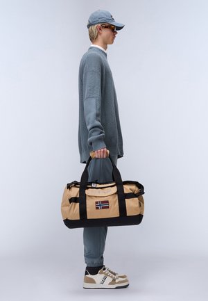 Borsa a tracolla beige con dettagli neri e un patch della bandiera. Realizzata in materiale resistente, dotata di manici robusti e una tasca con zip.